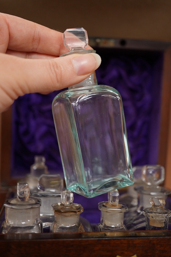 An early 19th century mahogany apothecary box, containing ten glass bottles, one with original paper label for the chemist Elam, 196 Oxford Street, London, with draw beneath containing a pair of scales, and weights, etc.